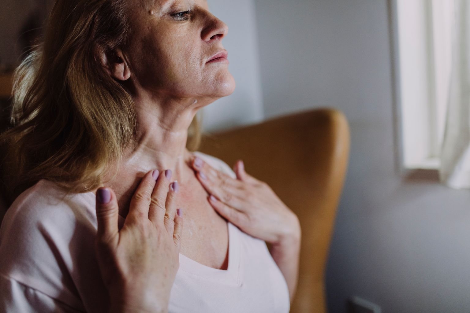 Woman applying moisturizer to her neck, neck skin tightening in Mississauga